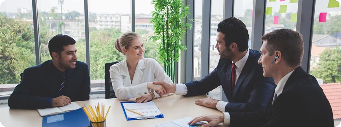 osoby na spotkaniu biznesowym korzystające ze słuchawek tłumaczących