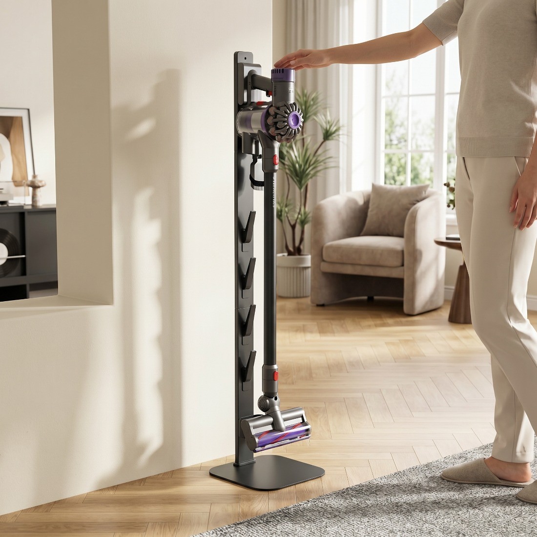 Osoba sięgająca po odkurzacz umieszczony na ergonomicznym stojaku podłogowym